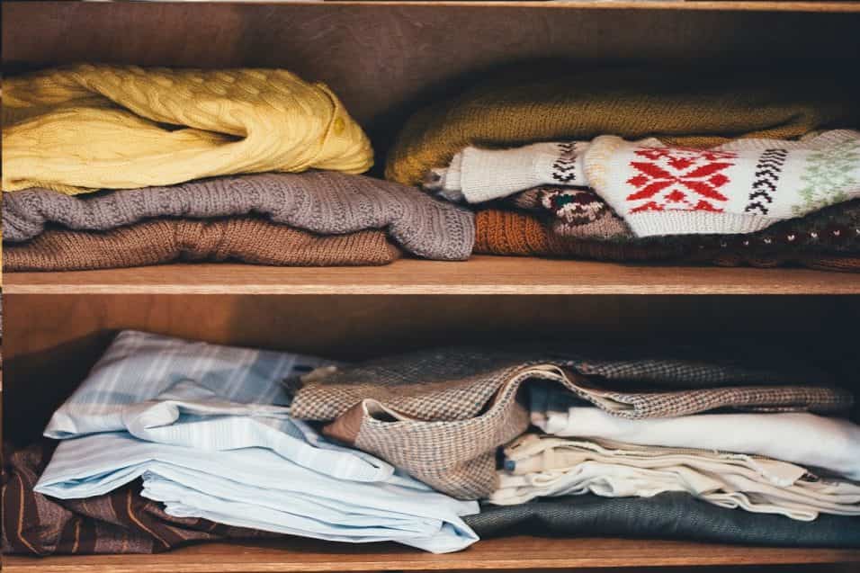 Vestiti riposti in scatole pulite per il cambio di stagione con lavanda per prevenire cattivi odori e batteri