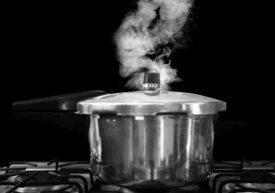 Pentola a pressione sul fuoco con valvola di sicurezza evidenziata